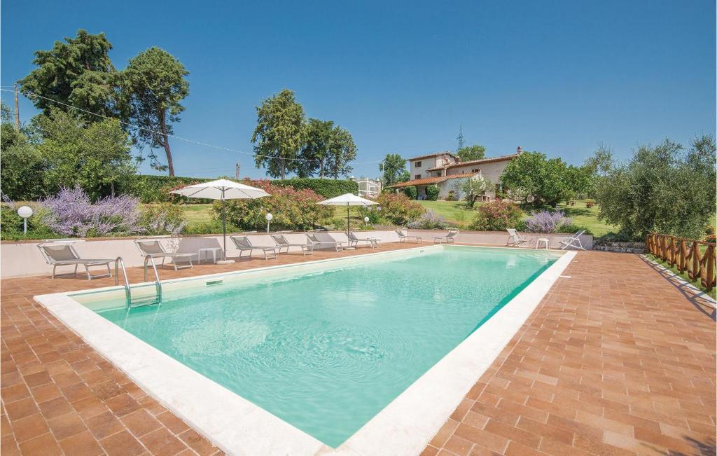 a swimming pool with chairs and umbrellas next to a house at Egidio in Vigne