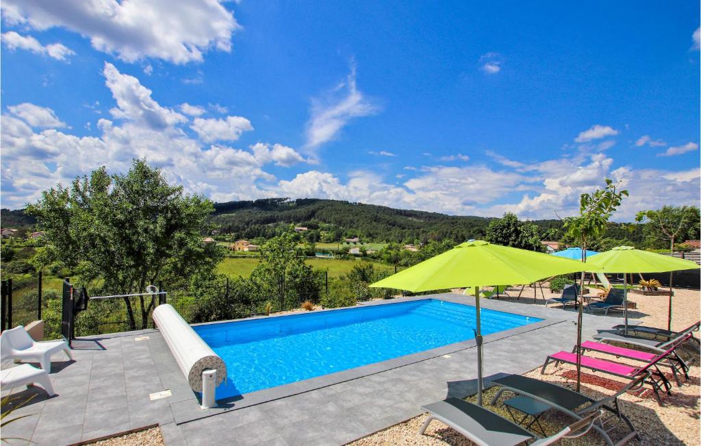 uma piscina com um guarda-sol verde e cadeiras em Cozy Home In Saint Sernin With Wifi em Saint-Sernin