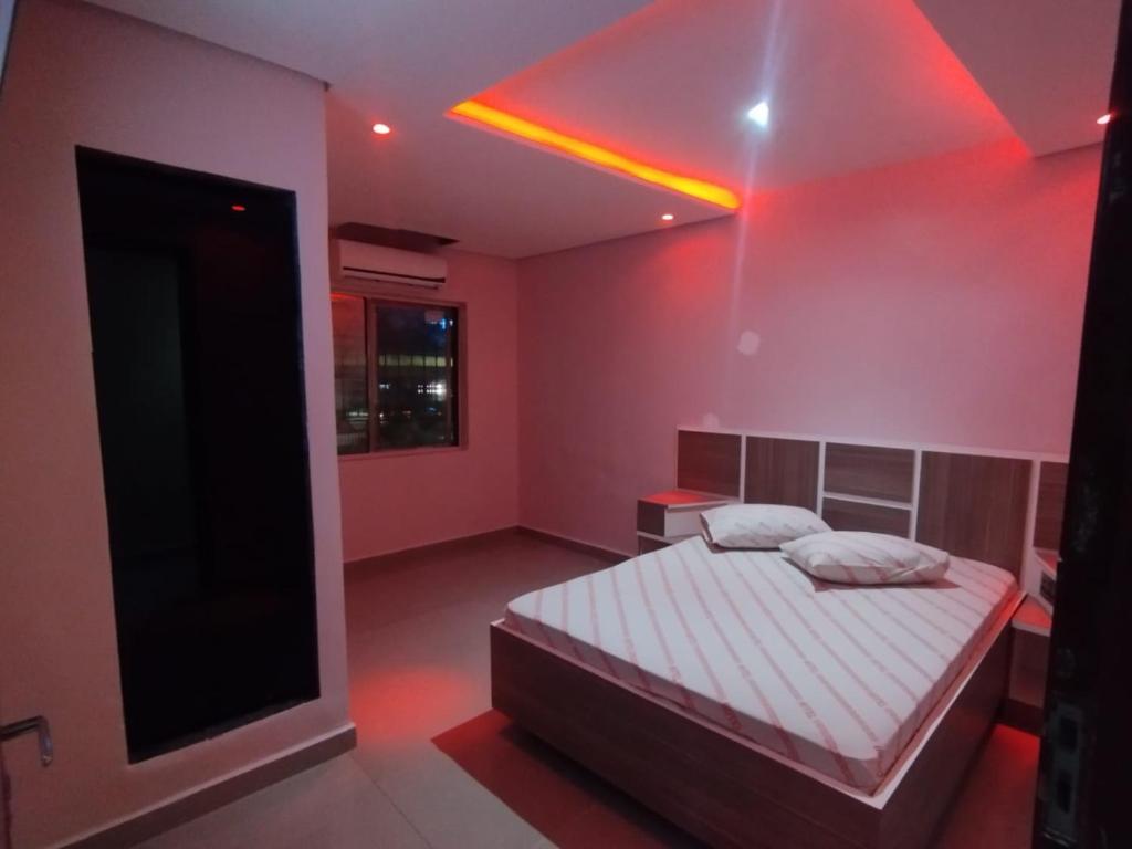 a bedroom with a bed and a red light at Hotel Simba in São Bernardo do Campo