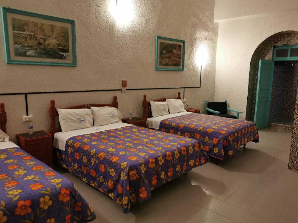 a hotel room with two beds with colorful sheets at HOTEL LIMÓN in Xalapa