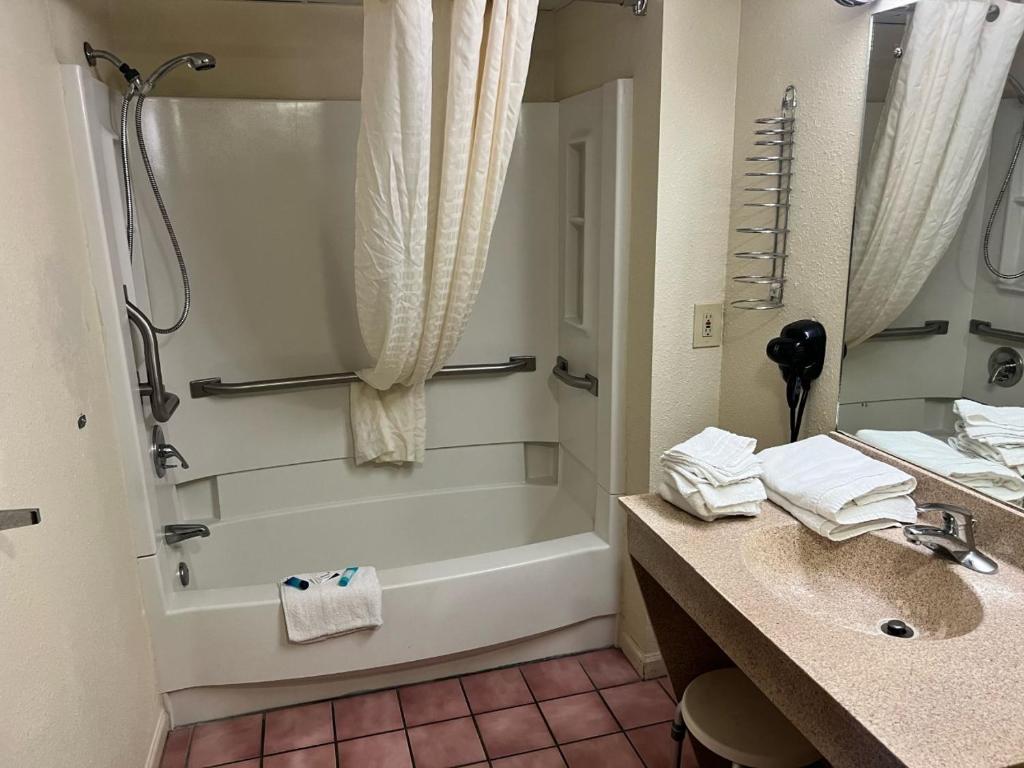 a bathroom with a tub and a sink and a shower at Days Inn By Wyndham Pigeon Forge South in Pigeon Forge