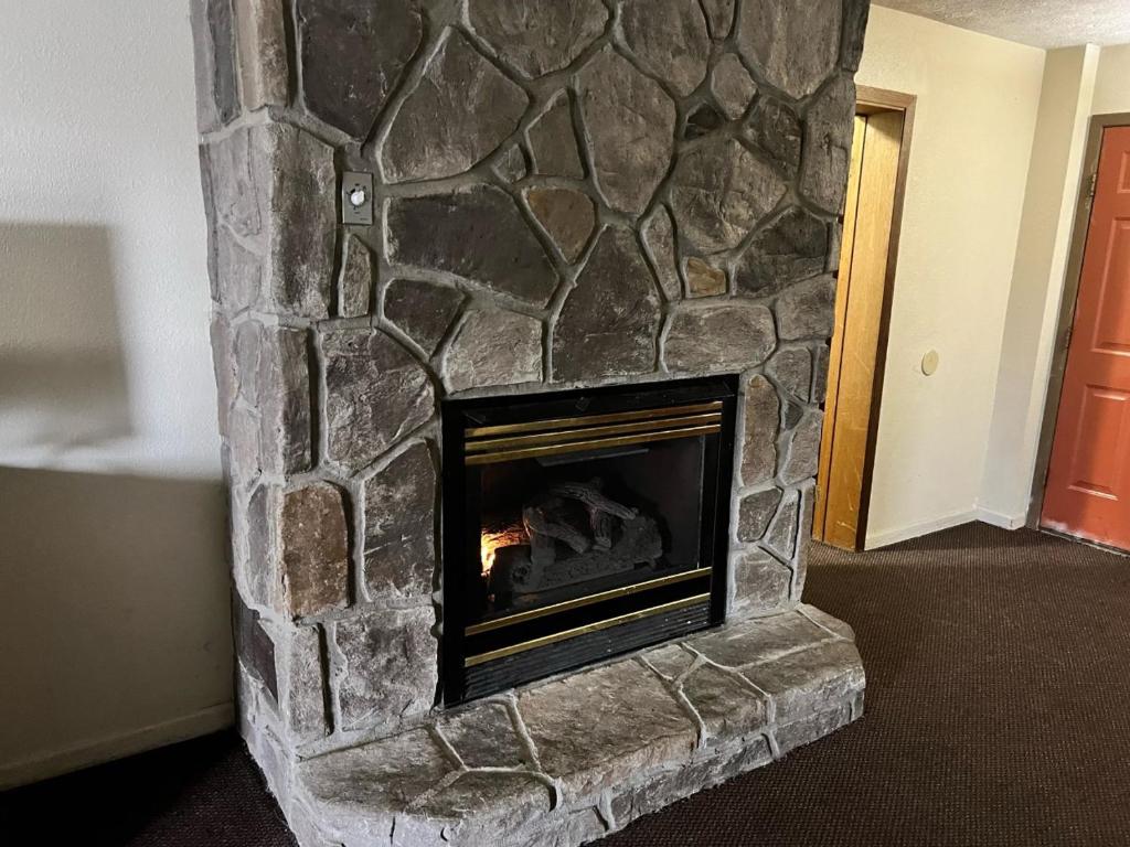 a stone fireplace with a fire in it at Days Inn By Wyndham Pigeon Forge South in Pigeon Forge