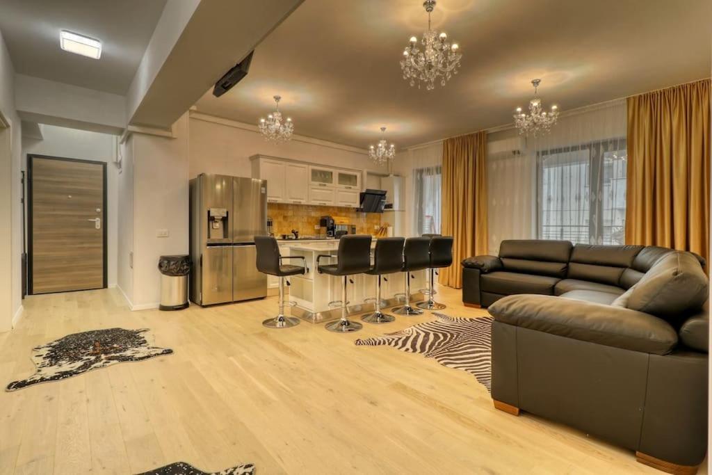een woonkamer met een bank en een keuken bij Luxurious 2 Bedroom Apartment in Herastrau in Boekarest