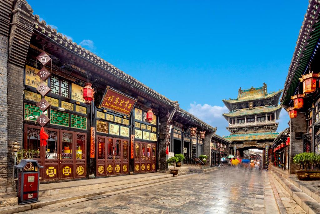 een straat in een Aziatische stad met gebouwen bij Pingyao Baichanghong Inn in Pingyao