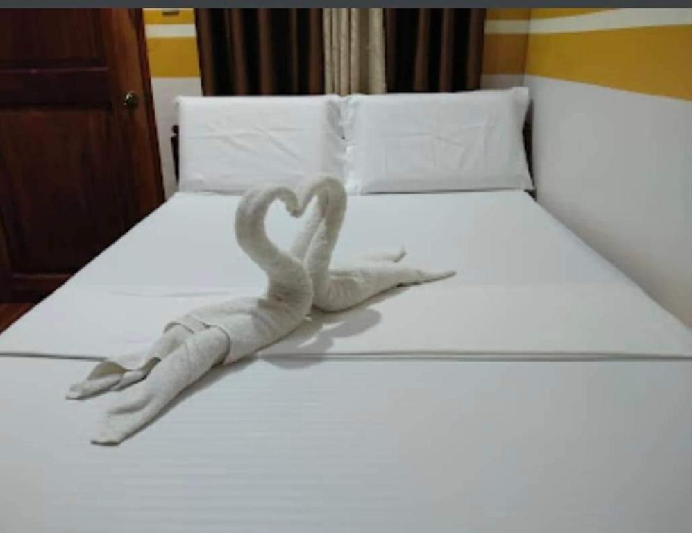 uma escultura de dois cisnes numa cama em SUN'S TRAVEL AND TOURS AGENCY CORON PALAWAN em Coron