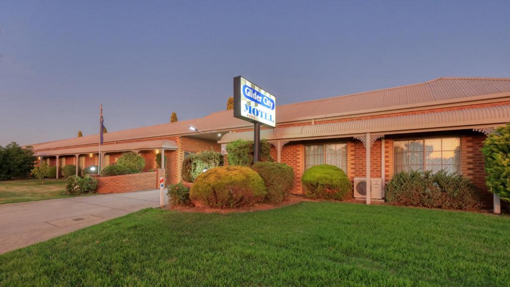 a hotel with a sign in front of a building at Glider City Motel Benalla in Benalla