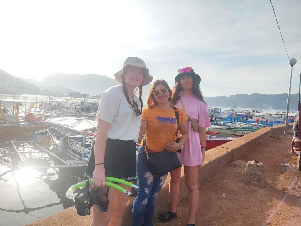 Un groupe de trois femmes debout à côté d'un port de plaisance dans l'établissement SUN'STAR TRAVEL AND TOURS AGENCY CORON PALAWAN, à Coron