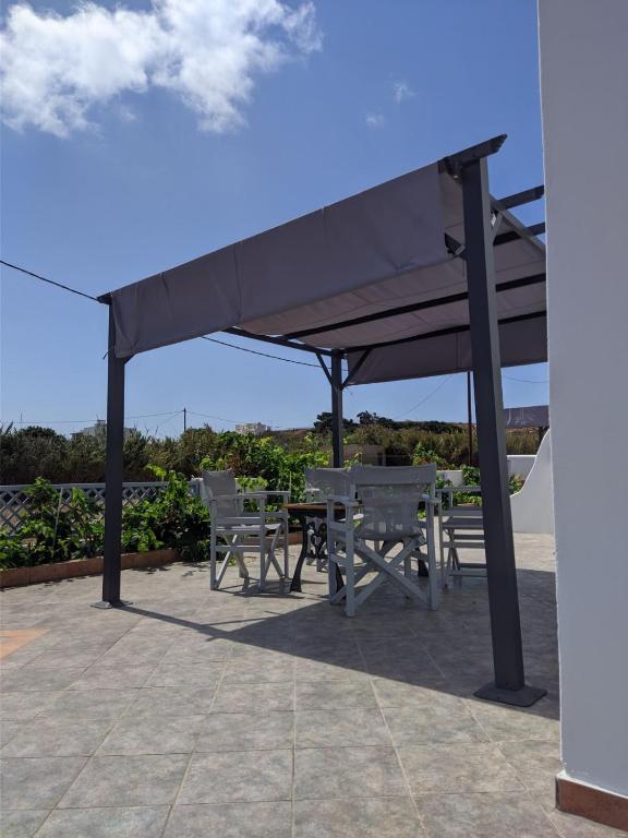 a picnic table and chairs under a canopy at Chrysiis House 2 in Maltezana