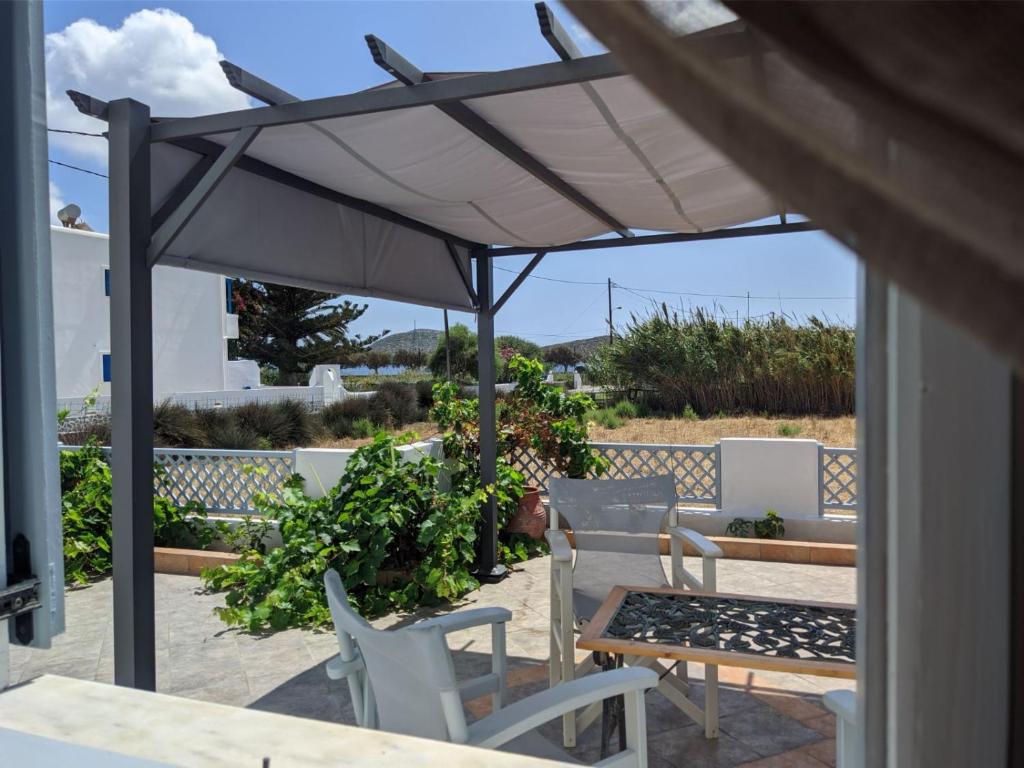 un patio con mesa, sillas y sombrilla en Chrysiis House 2 en Analipsi