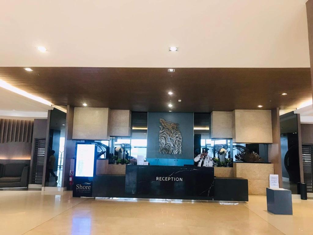 a hotel lobby with a reception desk in a building at Mall of Asia Condotel Pasay Philippines in Manila