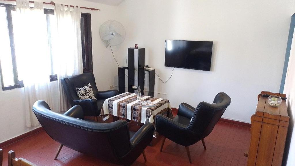 sala de estar con sillas, mesa y TV en LA CASA DE RUMI en Villa Rumipal