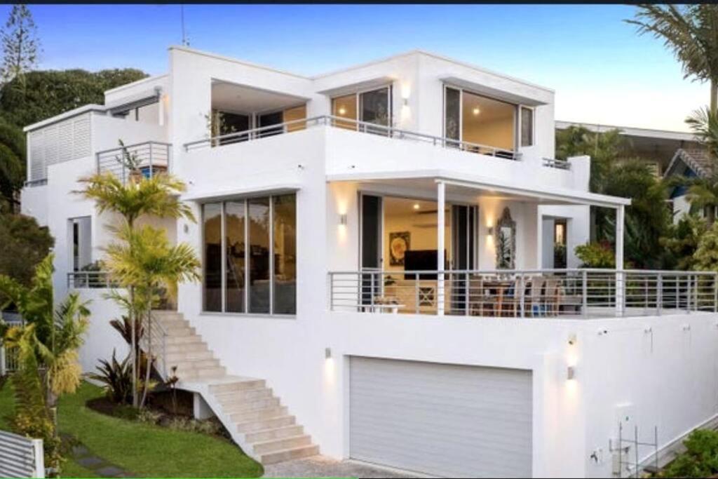 uma casa branca com muitas janelas em Luxury Alex Beach Home em Alexandra Headland