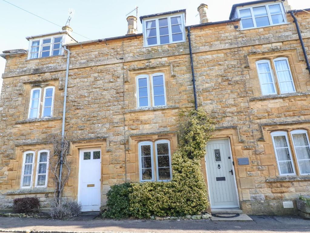 an old stone house with white doors and windows at Green Pump Cottage in Blockley