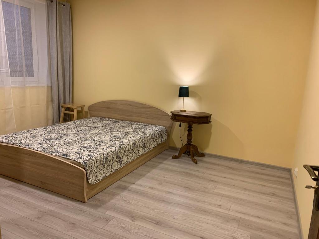 Dormitorio pequeño con cama y mesa en Butas pačiame miesto centre en Telšiai