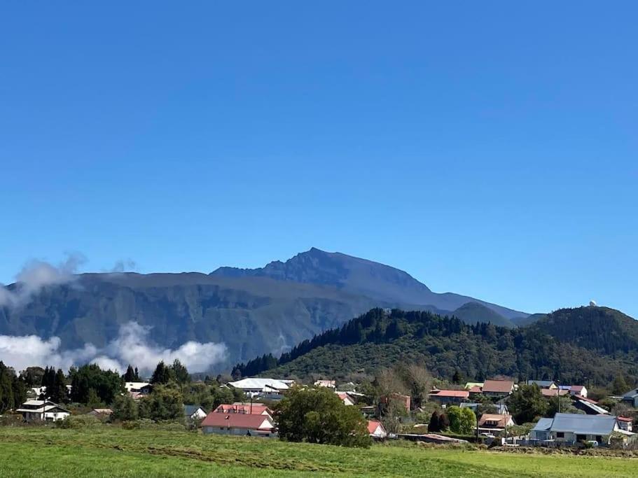 a small town in a valley with mountains in the background at Maison a Bourg- Murat proche de la cité du volcan in La Plaine des Cafres