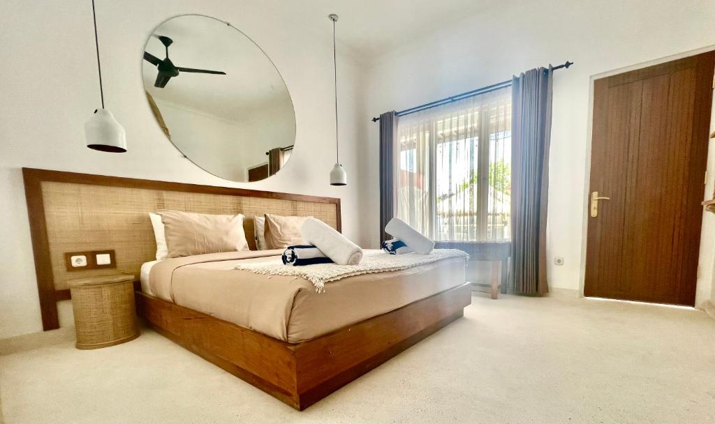 a bedroom with a bed with a large mirror on the wall at Love Song Boutique Hotel in Canggu
