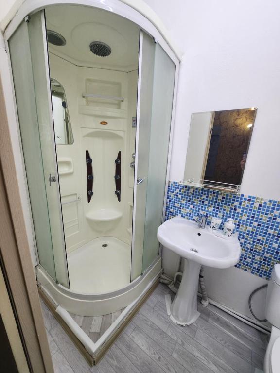 bagno con doccia e lavandino di Оазис a Almaty