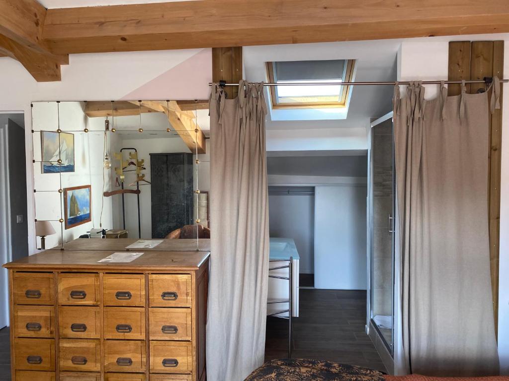 a bedroom with a wooden dresser and a mirror at Pitibi Maison d'Hote in Sanary-sur-Mer
