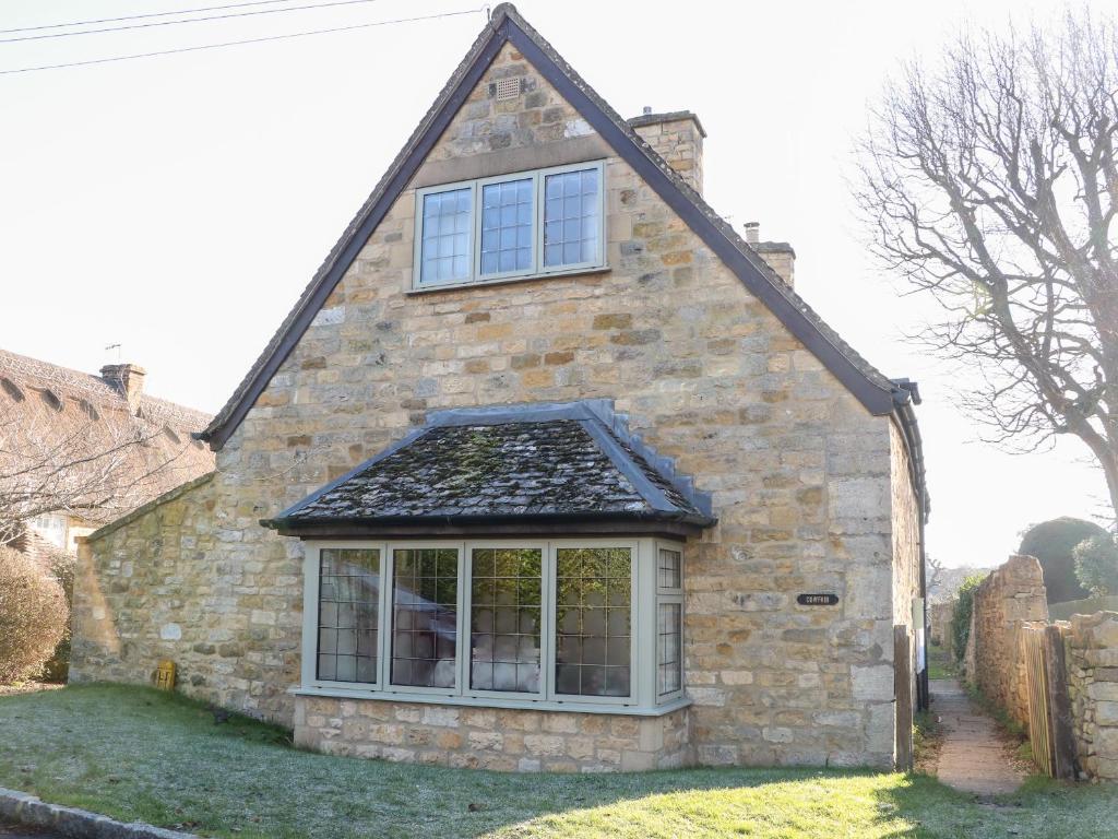 a brick house with a window on the side of it at Cowfair Cottage in Chipping Campden