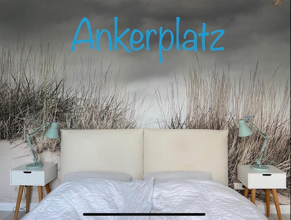 ein Schlafzimmer mit einem weißen Bett mit zwei Nachttischen und einem Schild, auf dem steht: in der Unterkunft Ankerplatz-1-Kiel in Kiel