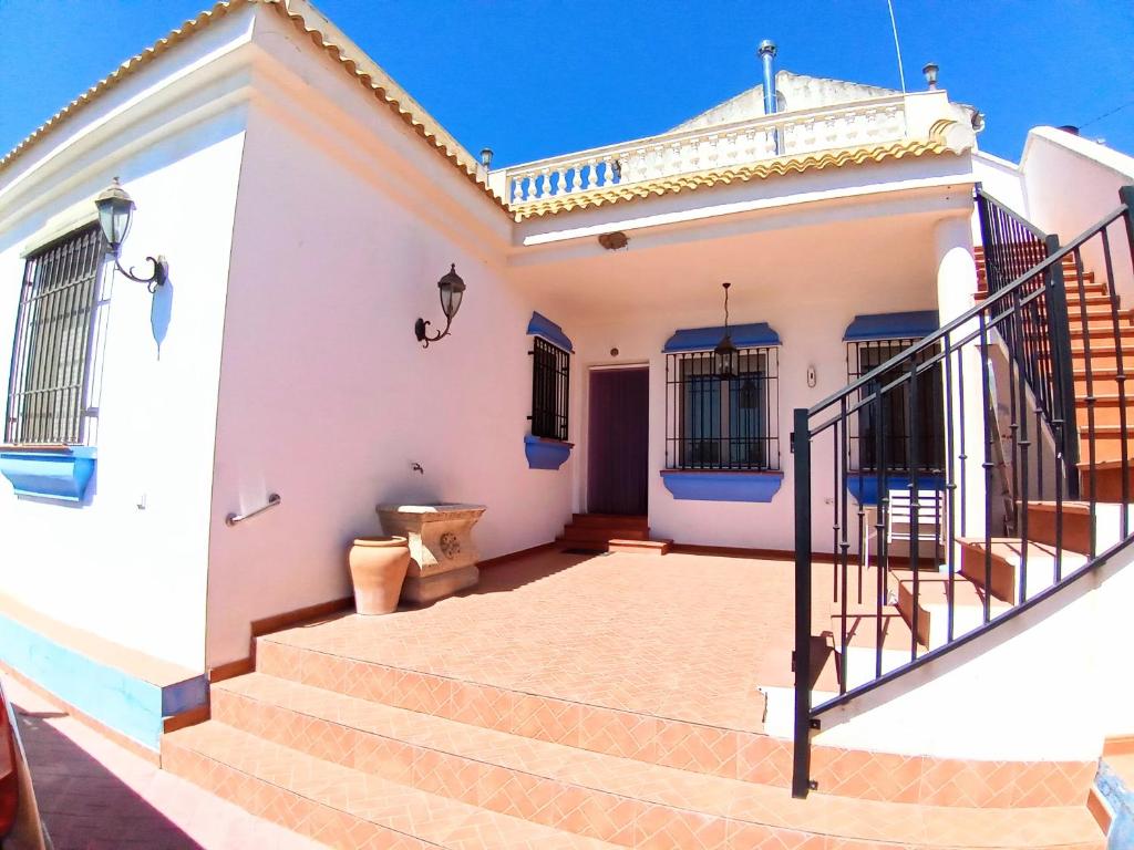 uma casa branca com escadas em frente em El Mirador de Pablo, casa con patio privado em Alomartes