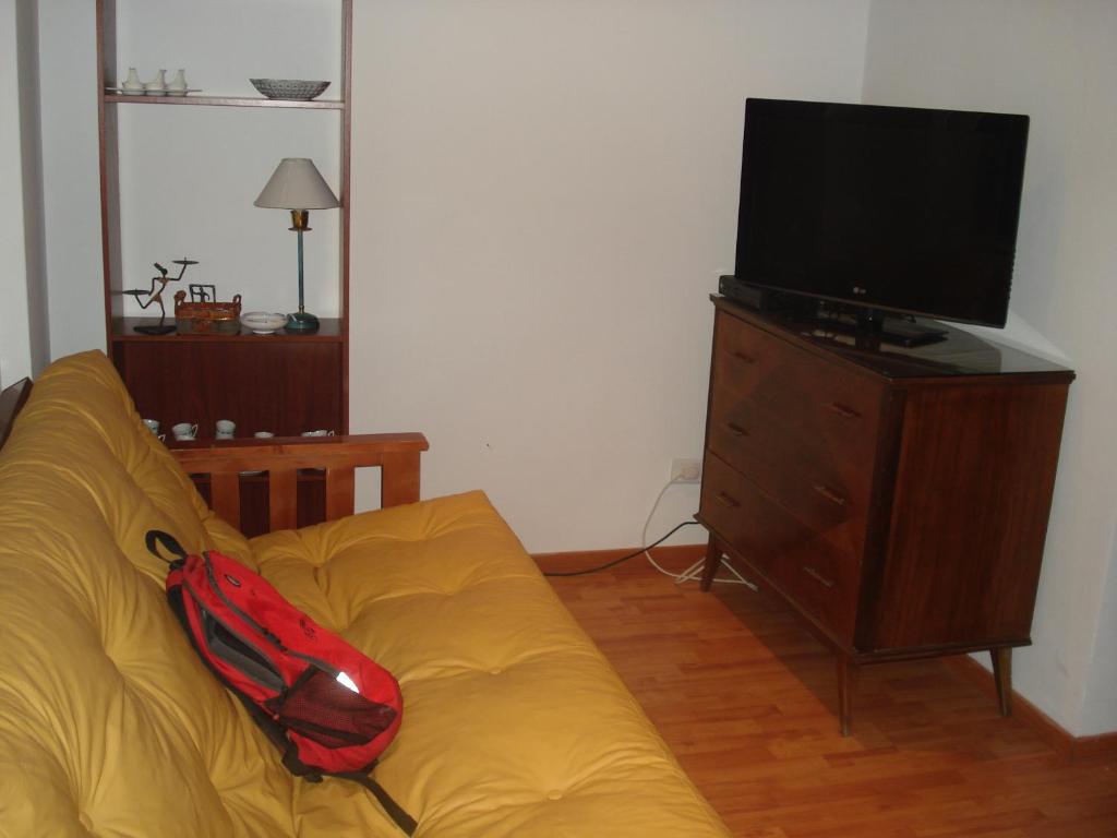 a red backpack sitting on a yellow couch in a living room at Mar Del Plata Loft in Mar del Plata