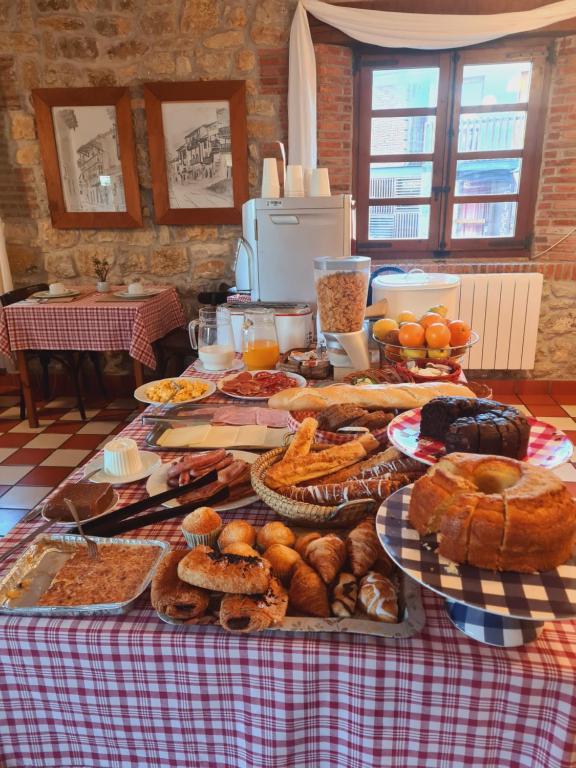 una mesa llena de diferentes tipos de pan y repostería en Hospederia Santillana en Santillana del Mar