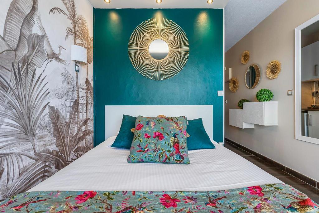 1 dormitorio con 1 cama con pared azul en Sunset 755 Naturist Port Nature, en Cap d'Agde
