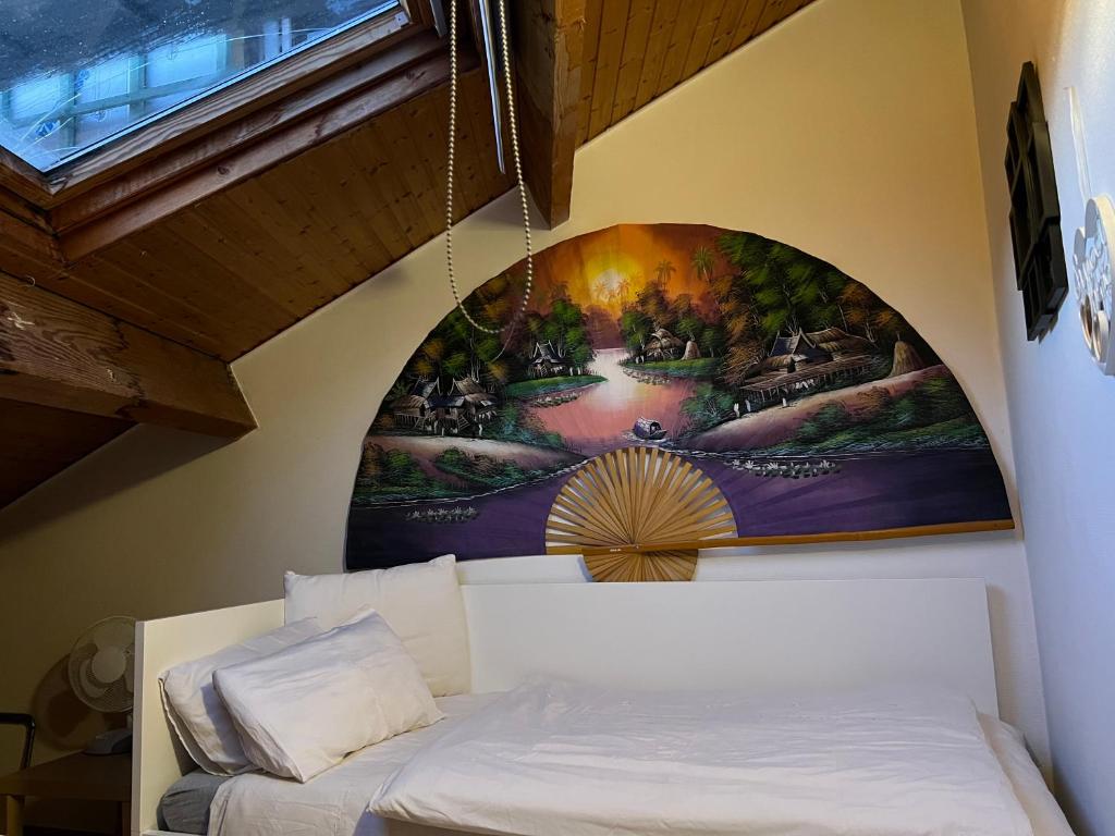 uma cama num quarto com uma pintura na parede em Petite maison choux em Bouillon