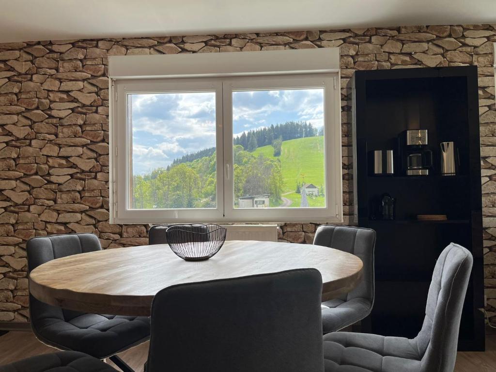 a dining room with a table and a window at Gîtes BEL'M in La Bresse