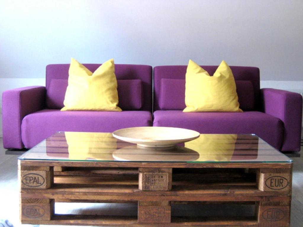 a purple couch with two yellow pillows and a coffee table at Ferienwohnungen Ostengasse 22 in Regensburg