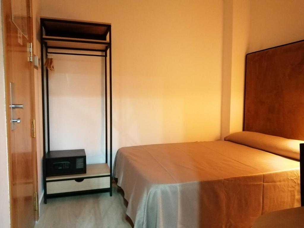 a bedroom with a bed and a tv in it at Hotel Universal in Granada