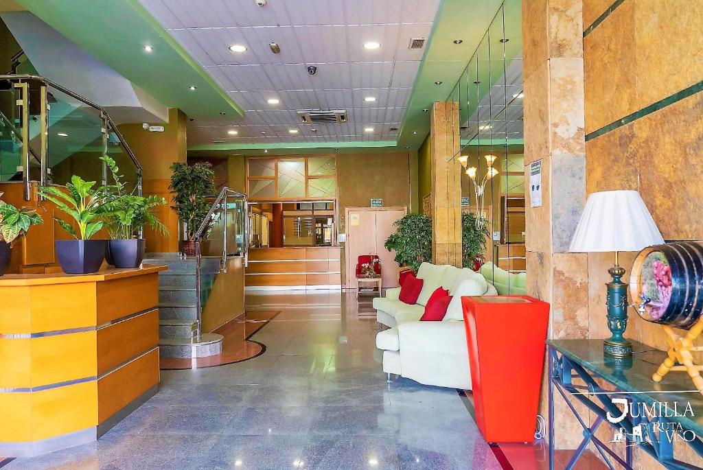 un vestíbulo con un sofá blanco y algunas plantas en Hotel Pio XII Jumilla, en Jumilla