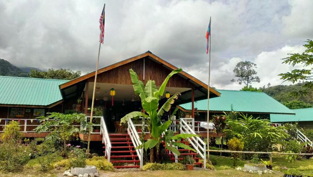 een huis met twee vlaggen ervoor bij Kinabalu Poring Vacation Lodge in Kampung Poring