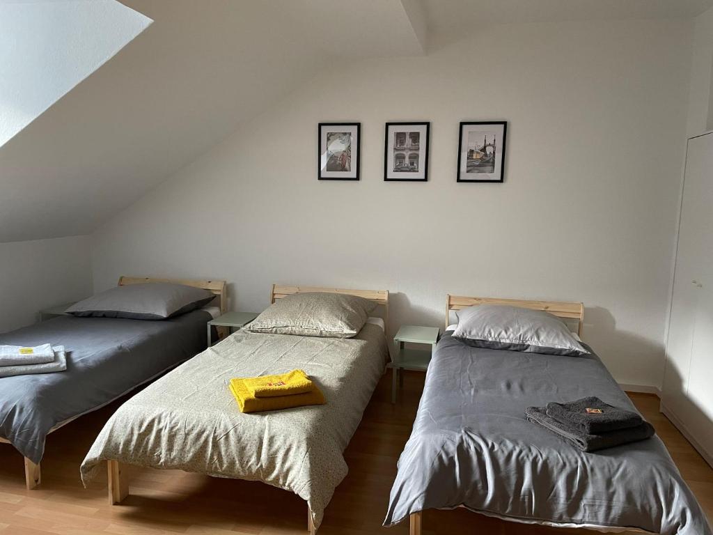 a bedroom with two beds and two pictures on the wall at - SANO Apartments - DGR - Hagen Zentral - Free Parking - WIFI - Washing Machine in Hagen