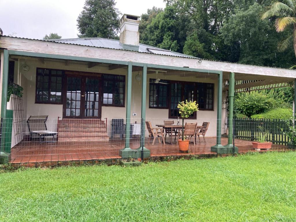 um alpendre de uma casa com uma mesa e cadeiras em Irish Hills em Hilton