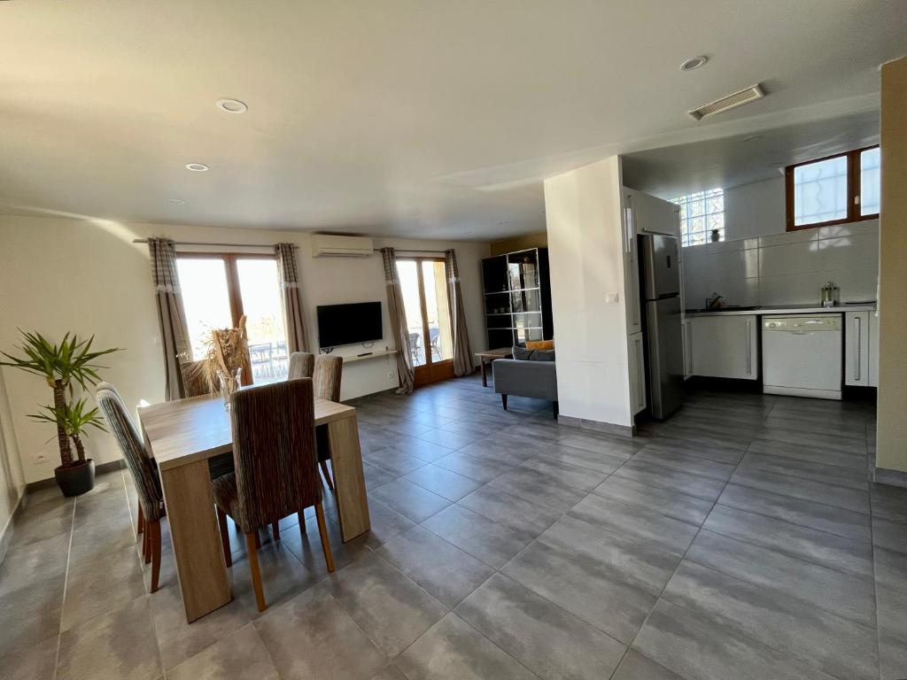 a kitchen and living room with a table and chairs at Maison spacieuse avec grand jardin et parking à 20min de Lyon in Simandres