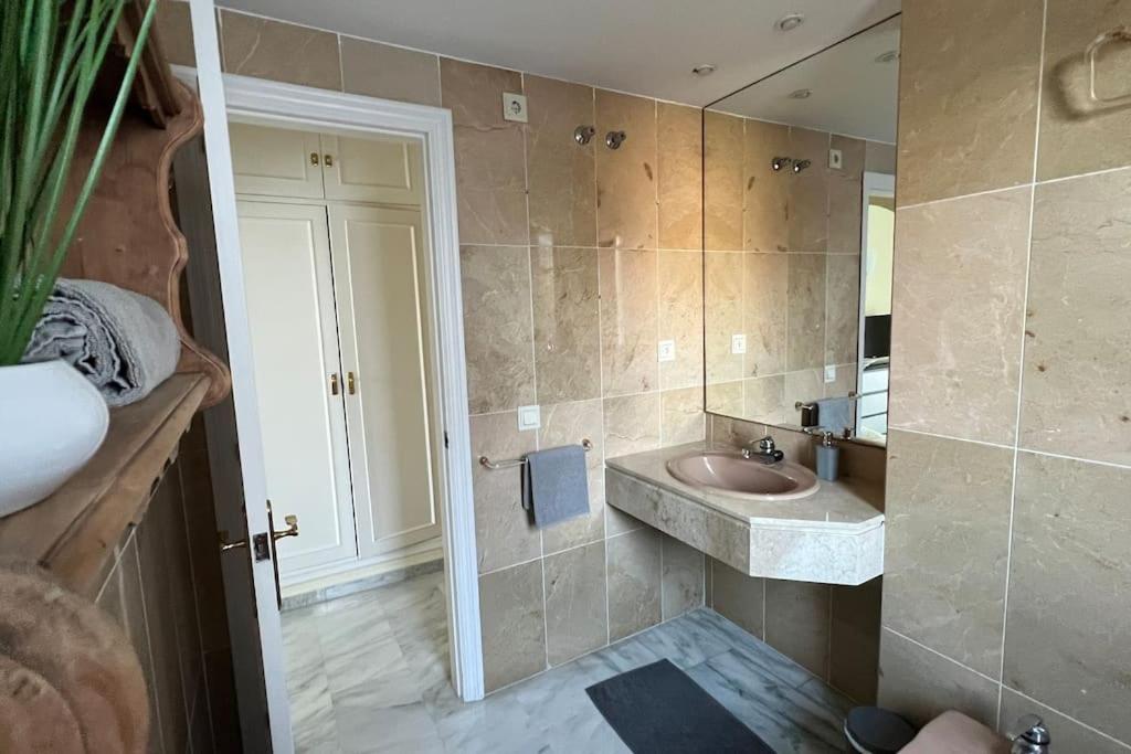 łazienka z umywalką i lustrem w obiekcie Costalita - 2 bedroom apartment 350m from the beach w mieście Estepona