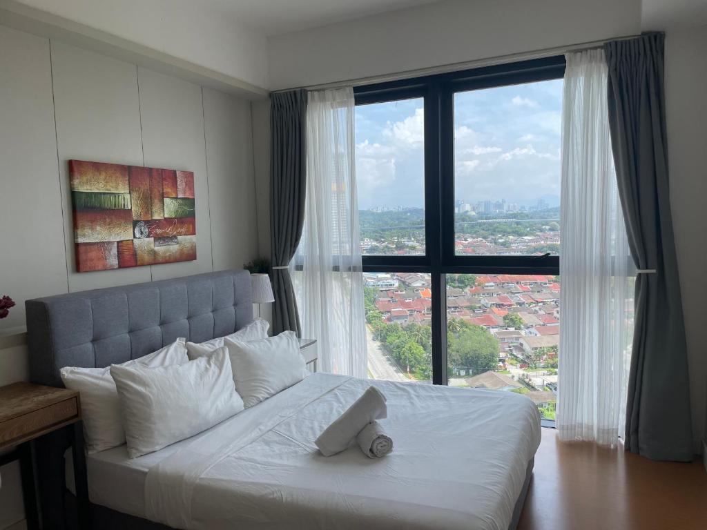 Schlafzimmer mit einem weißen Bett und einem großen Fenster in der Unterkunft THE HUB SS2 in Petaling Jaya