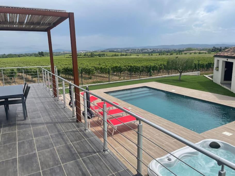 a deck with a swimming pool and a table and a table at La Moulinière in Pennautier