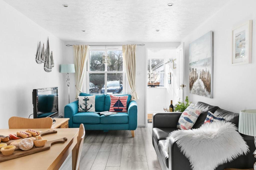 a living room with a blue couch and a table at Pippin Cottage - Character cottage with the spirit of the sea in Salcombe