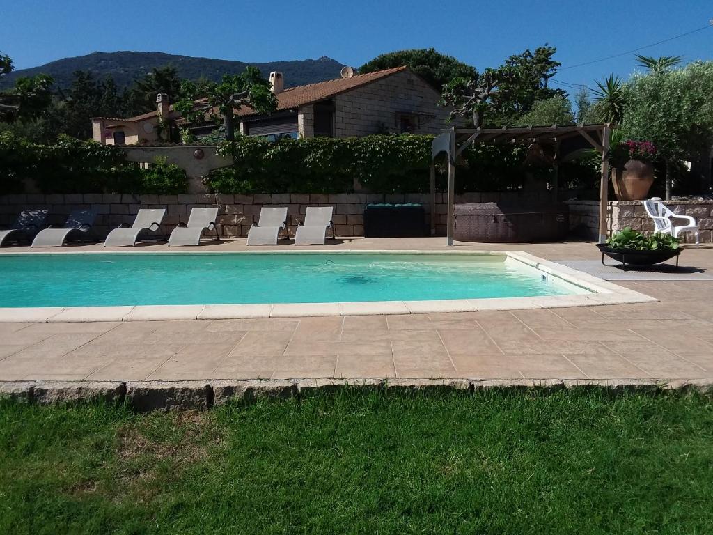 a swimming pool with lounge chairs and a house at Magnifique villa piscine Propriano in Olmeto
