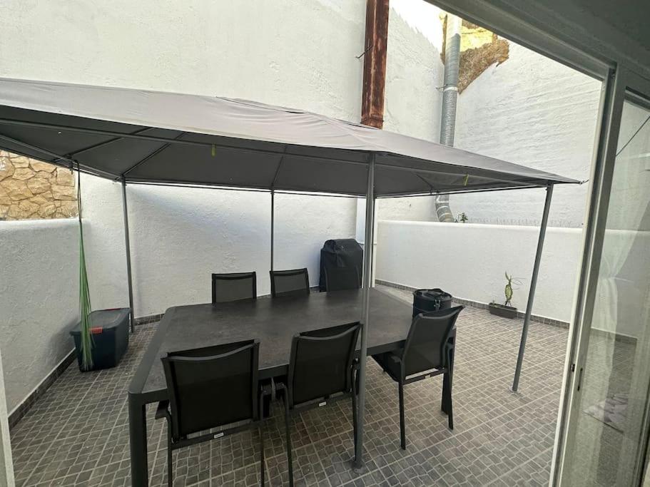 un tavolo e sedie sotto un ombrellone su un patio di Apartamento T2 com terraço a 100 metros da praia a Carvoeiro