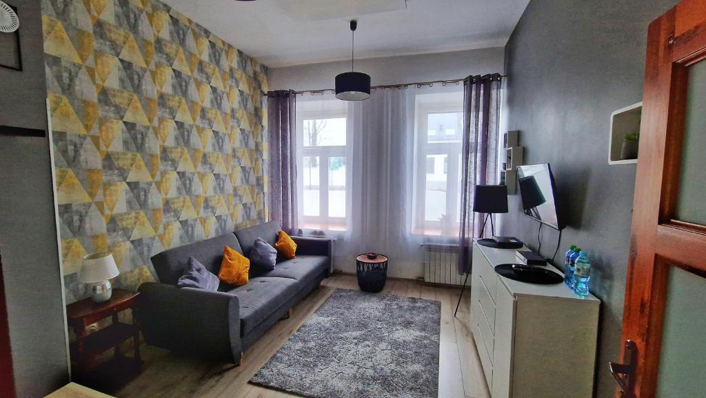 uma sala de estar com um sofá e uma janela em Pokoje przy Arkadii em Suwałki