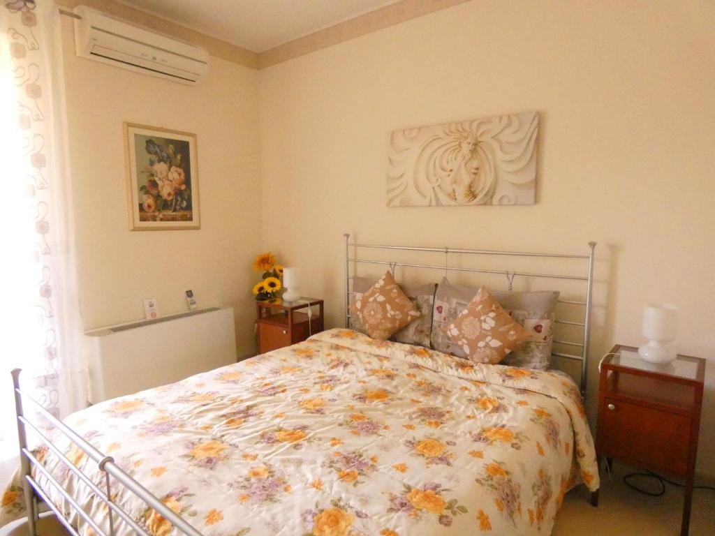 a bedroom with a bed with a floral bedspread at Villa Magnolia B&B in Taormina