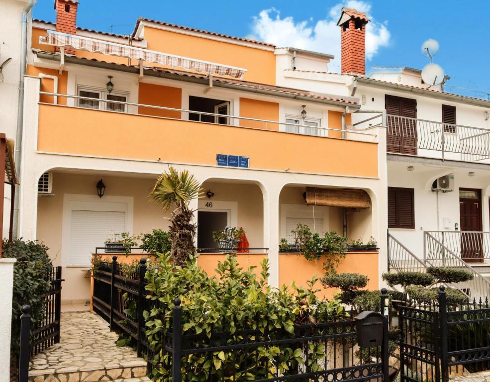 a house with a fence in front of it at Apartments Jurić in Vrsar