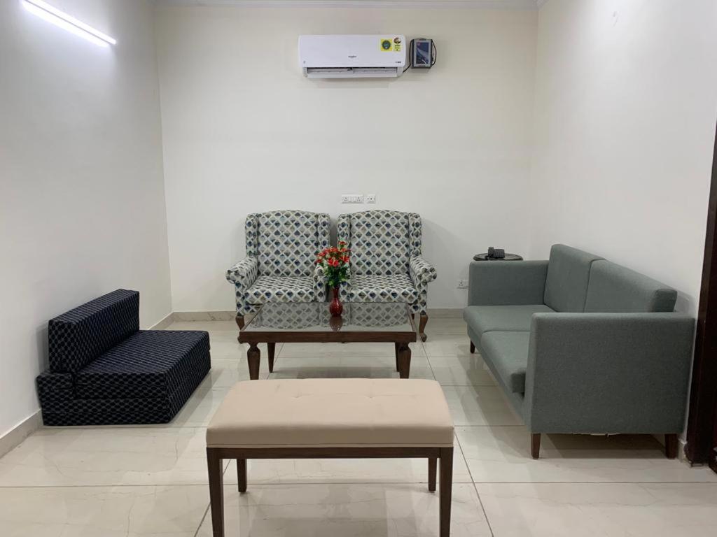 ein Wohnzimmer mit 2 Stühlen und einem Sofa in der Unterkunft Staywell360 in Chandīgarh