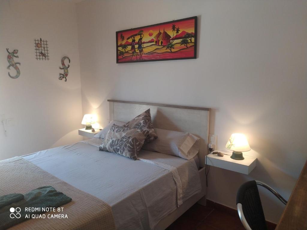 a bedroom with a bed with two lamps on it at Habitación privada en casa particular, montaña in Olesa de Bonesvalls
