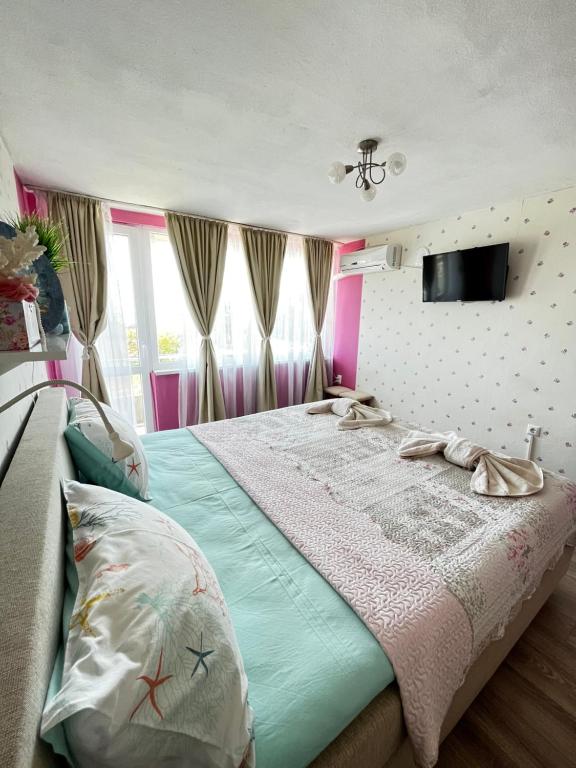 una camera con letto e TV a parete di Апартамент във вила Артемида a Varna