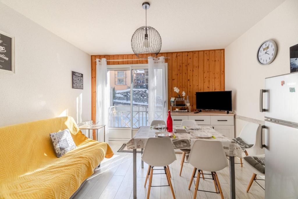 uma sala de estar com um sofá amarelo e uma mesa em La Baregine em Barèges